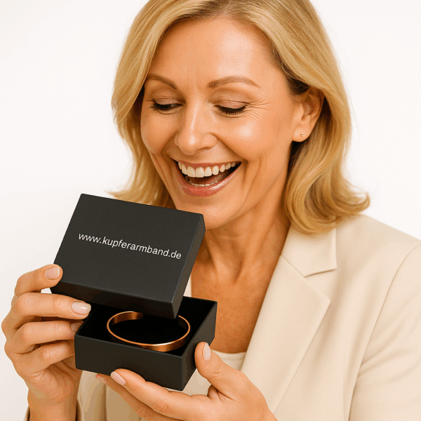 Elegante Frau mittleren Alters öffnet schwarze Schmuckbox „www.kupferarmband.de“ – poliertes Kupferarmband halb sichtbar